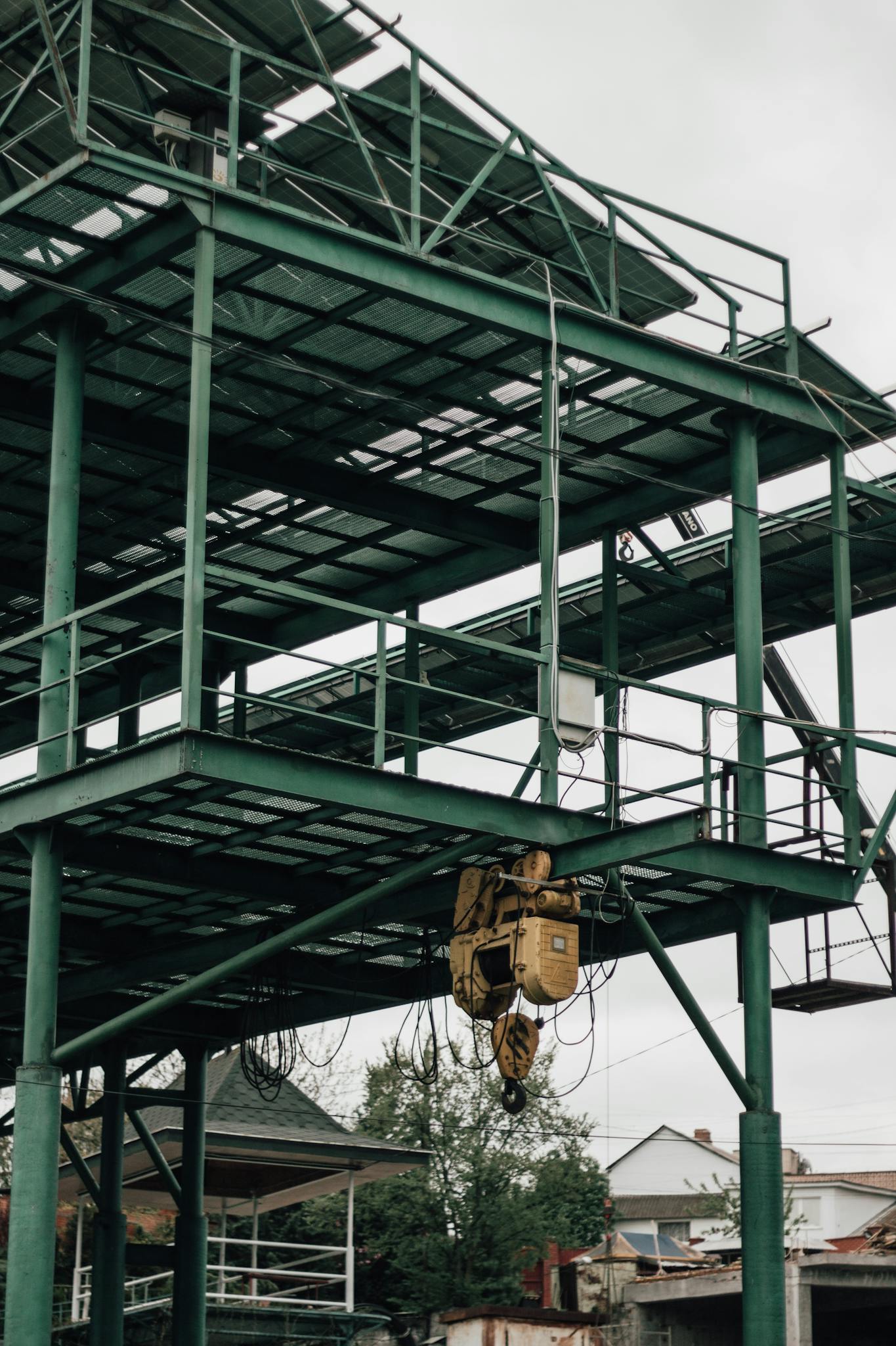 Steel structure under construction with visible hoist winch and scaffolding.